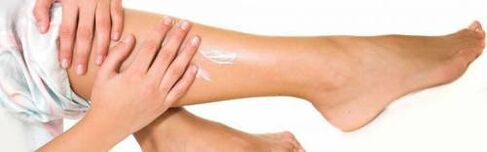 Applying a medicated cream to legs with enlarged veins
