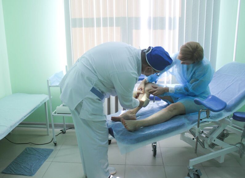 A surgeon examines a patient's veins before performing surgery.